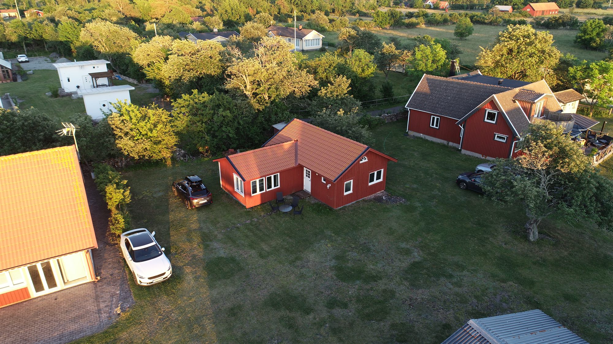 Flygbild över stugan Solhäll i kvällssol på Öland